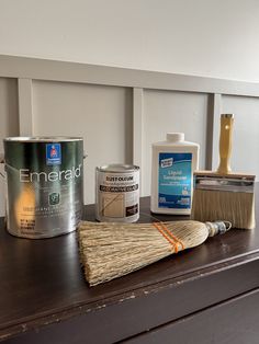 some paint and brushes are sitting on top of a wooden table next to a can