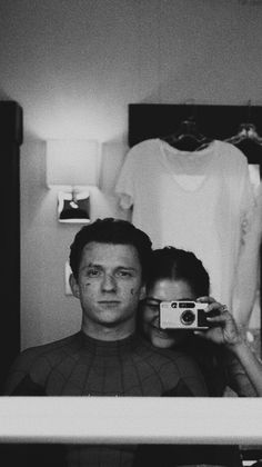 a man and woman taking a selfie in front of a mirror