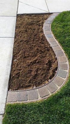 a brick path is in the middle of some grass and dirt on the side walk