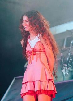 a woman standing on top of a stage holding a microphone