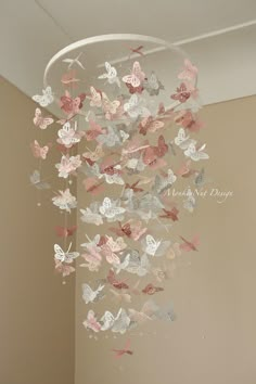 a chandelier with butterflies hanging from it's sides in a room next to a wall