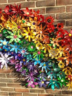 a bunch of colorful pinwheels on a brick wall