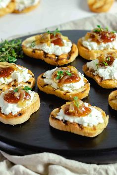 mini appetizers with goat cheese and herbs on a black platter, ready to be eaten