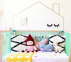 a baby crib with stuffed animals and pillows on it's bed in a child's room