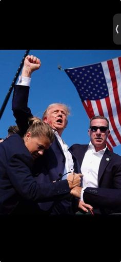 two men in suits and one woman with an american flag on the back of their shoulders