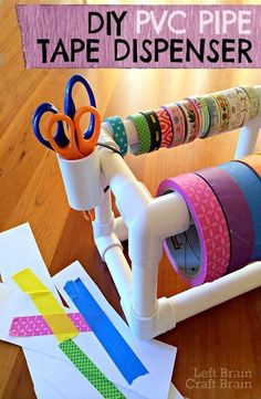 some tape dispensers are sitting on a table with paper and scissors in them