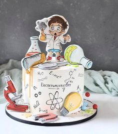 a cake decorated with an image of a boy holding a beaker and science equipment