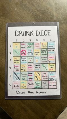 a sign that says drunk dice on the side of a wooden table next to a cup