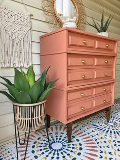 an orange dresser next to a potted plant