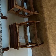 two wooden chairs sitting on top of a tiled floor