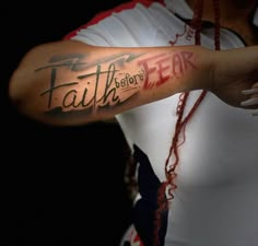 a man with a tattoo on his arm that says faith before fear