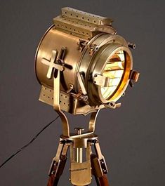 an old fashioned light is sitting on a tripod