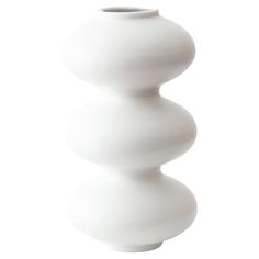 a tall white vase sitting on top of a table