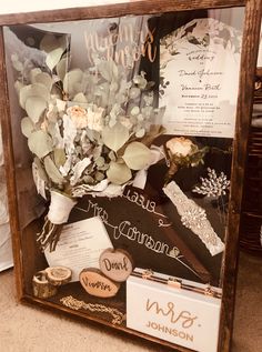 a wooden frame with flowers and other items in it