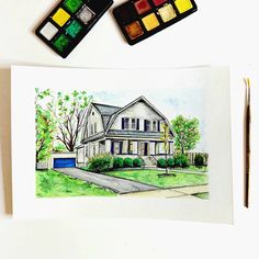 a watercolor painting of a house next to some paintbrushes on a table