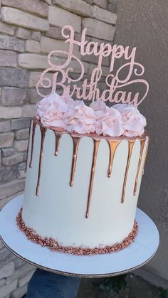 a birthday cake with icing and pink flowers on top