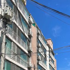 an apartment building with balconies and balconyes on the second floor, against a blue sky