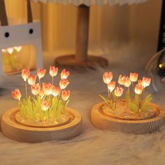 two wooden vases filled with flowers on top of a table