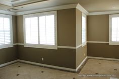 an empty living room with two windows and no one in the house or someone else