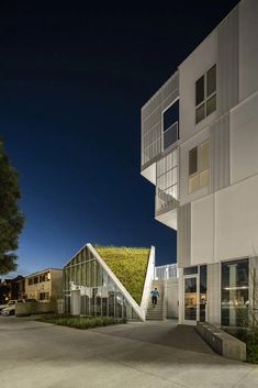 a building with a green roof and stairs leading up to it's second story