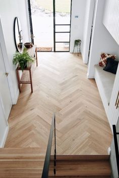 an overhead view of a wooden floor and stairs in a house with glass doors leading to the outside