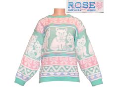 A super cute 1980s vintage Rose brand pullover sweater. Adorable cats / kittens and bows textured acrylic knit in mint green, pink, purple, and white with sparkly silver Lurex threads. Made in USA. Very kawaii / Fairy Kei style! Excellent condition, no stains, holes, or pilling. No fading, the color is even and vibrant. The only issue is a small area of bunched up threads along the seam on the underside of one sleeve, it's just a small manufacturing error. It's only noticeable if you're looking for it. Overall appearance is excellent. No size tag but it's generously cut and would fit all sizes up to Large, possibly Extra Large. To ensure a perfect fit, it's best to measure yourself or a garment you already own and compare to the measurements below:  Bust: 42" Waistband: 34", stretches to 4 Kawaii Fairy, Rose Brand, Cat Sweater, Vintage Pullovers, Rose Sweater, Rose Vintage, Women's Sweaters, Thrift Shopping, Kitty Cat