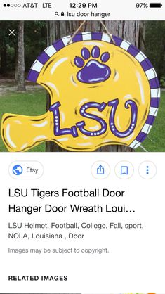 the lsu tigers football door hanger is on display in front of a tree and grass area