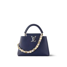 This exquisite capucines mm handbag displays a rich mix of materials and textures. Crafted from luxe taurillon leather, it is fitted with the beautiful new blossom chain: its golden metal links are interlaced with pastel calfskin and set with enameled and gold-tone monogram flowers. An lv signature in colored enamel finishes the piece with a jewel-like touch. Handbag Displays, Handbag Display, Bag Display, Materials And Textures, Louis Vuitton Official, Luxury Handbags, Cowhide Leather, Leather Handbags