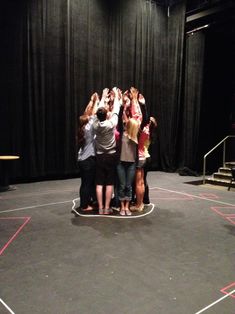 a group of people standing on top of a basketball court with their hands in the air