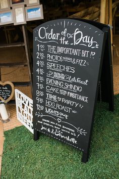 a chalkboard sign sitting on top of a green grass covered field next to signs