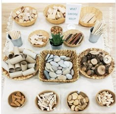 a table topped with baskets filled with lots of different types of rocks and wood sticks