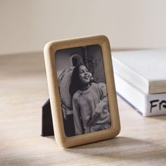 an old photo frame sitting on top of a table next to a stack of books