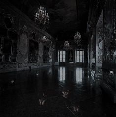 an empty room with chandeliers and mirrors on the walls in black and white