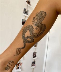 a woman's arm with a tattoo on it and a dragon in the middle