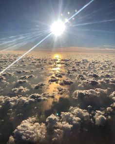 the sun shines brightly over clouds in this photo taken from an airplane's window