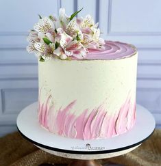 a white and pink cake with flowers on top