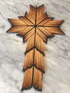 a cross made out of wooden sticks on a marble surface