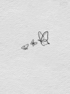 two butterflies flying next to each other on a white wall with the words love written in black ink