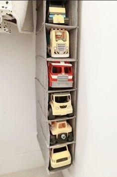 a toy car storage unit in the corner of a room with white walls and carpet