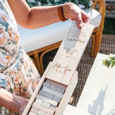 a woman is holding a wooden block game