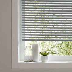 a window sill with two vases and a succulent