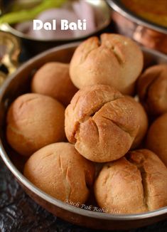 several rolls in a metal bowl on a table