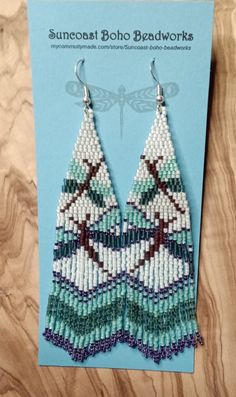 a pair of beaded earrings sitting on top of a card