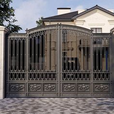 an iron gate in front of a white house