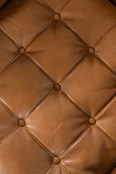 an upholstered brown leather seat with buttons