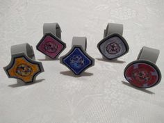 six rings with different designs on them sitting on a white tableclothed surface,