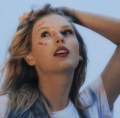 a woman with her hands on her head and face painted in the shape of letters