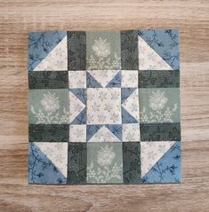 a blue and white patchwork quilt on top of a wooden table