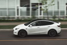 a white tesla suv driving down the road