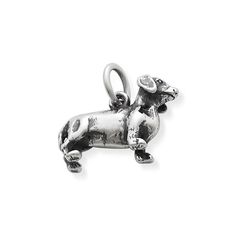 a silver charm with a small dog on it's back end, sitting in front of a white background